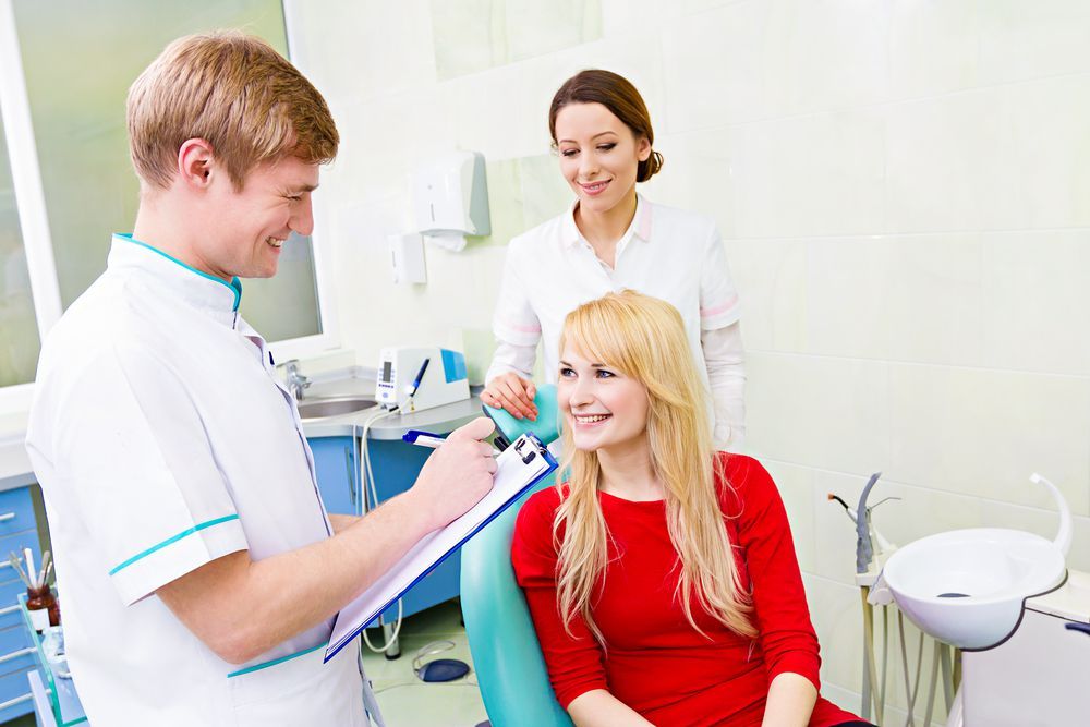 male and female dentist talking with female patient