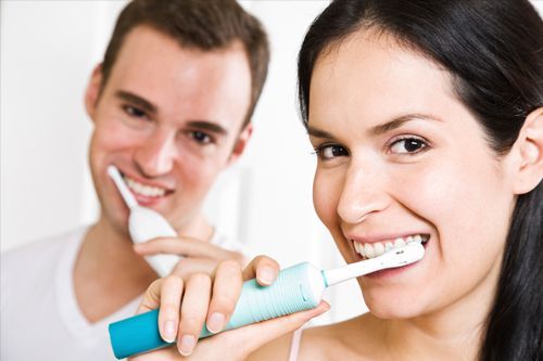 man and woman brushing teeth