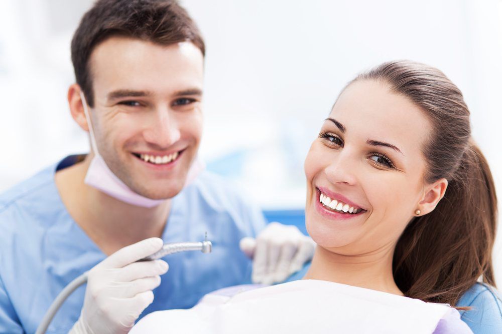 male dentist and female patient smiling