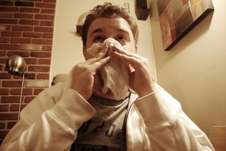 man blowing his nose