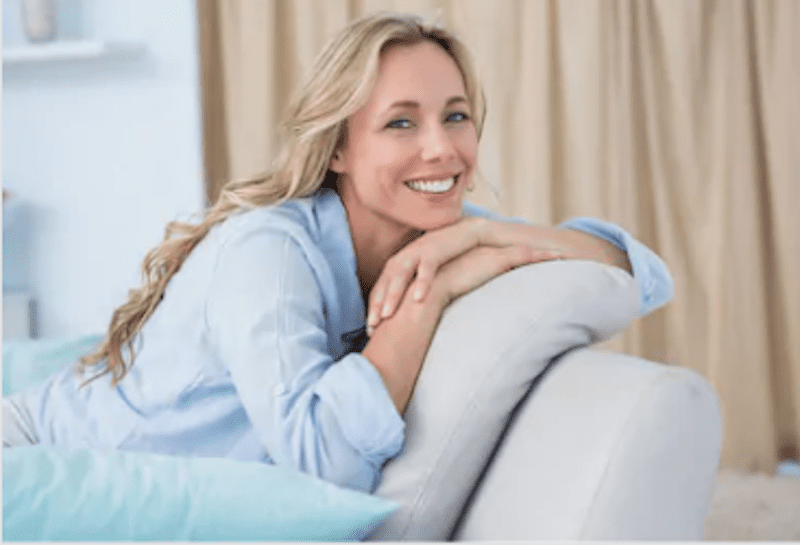 woman smiling while sitting on couch