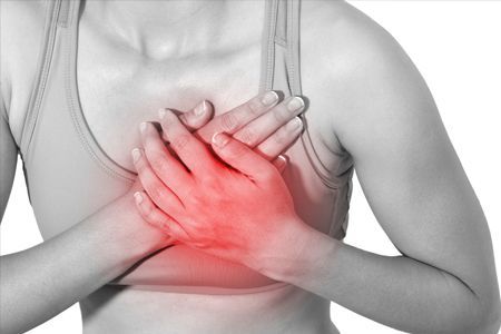 woman holding her chest in pain