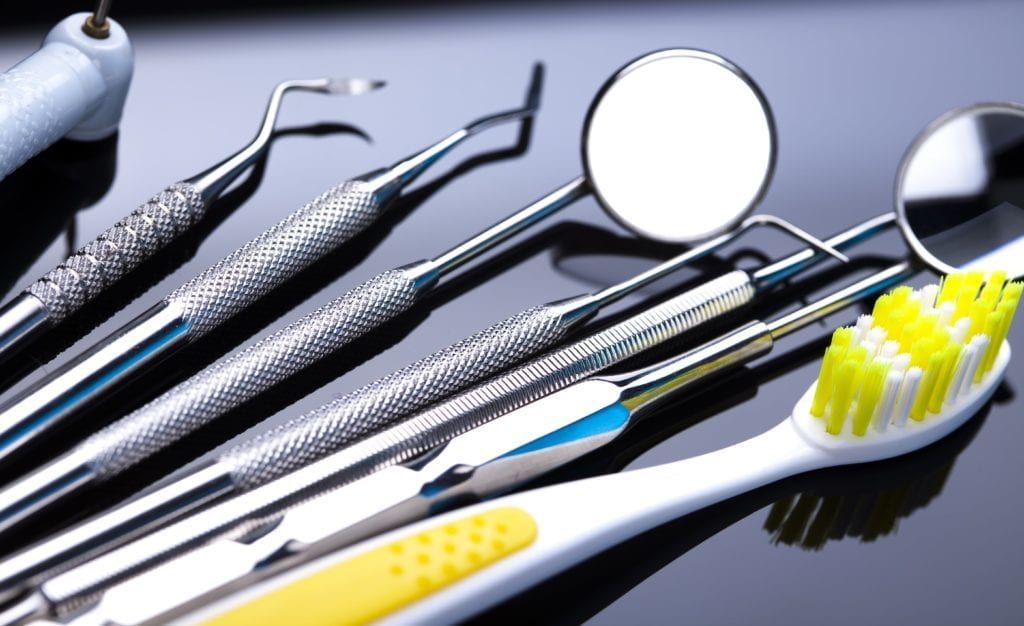 dentist tools besides a yellow toothbrush