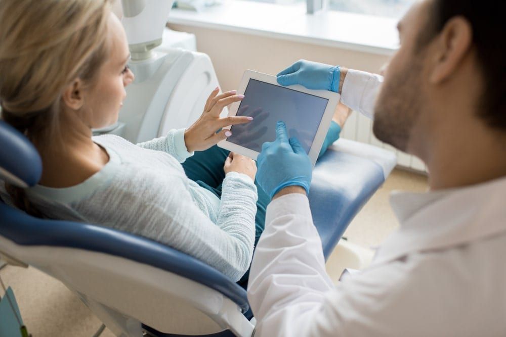 Dentist explaining treatment plan using a tablet