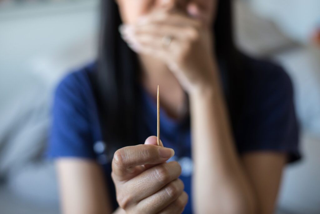 woman holding up a toothpick